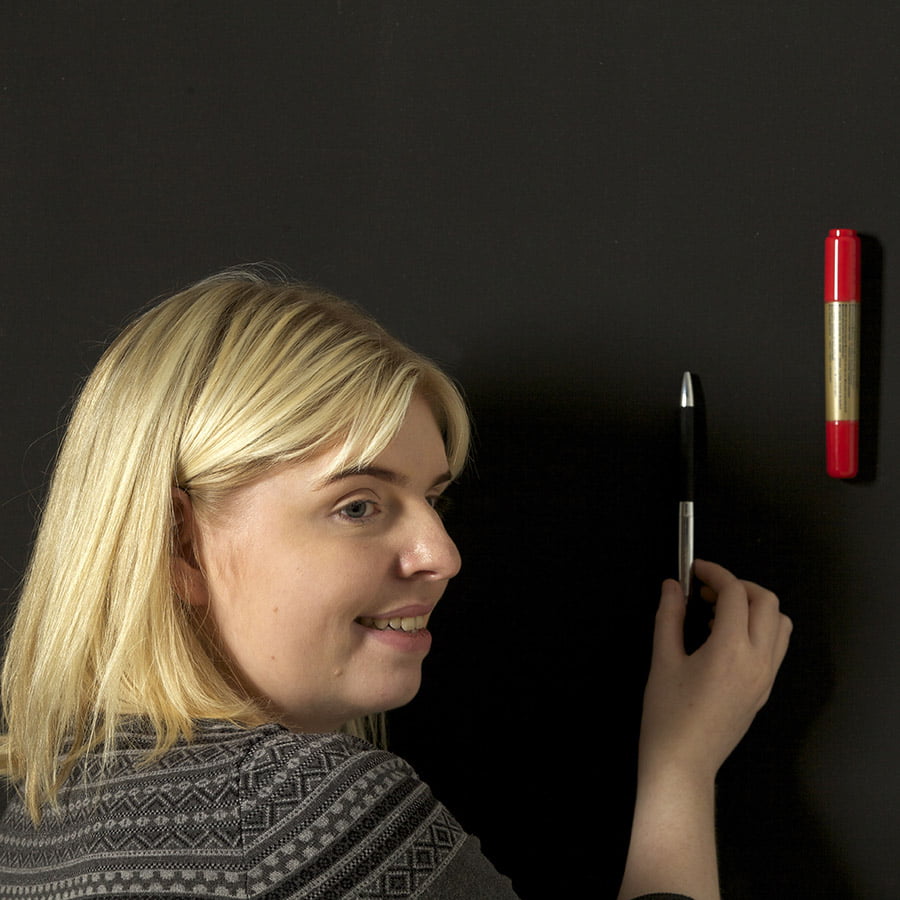 Mujer colocando artículos en pintura super magnética para paredes